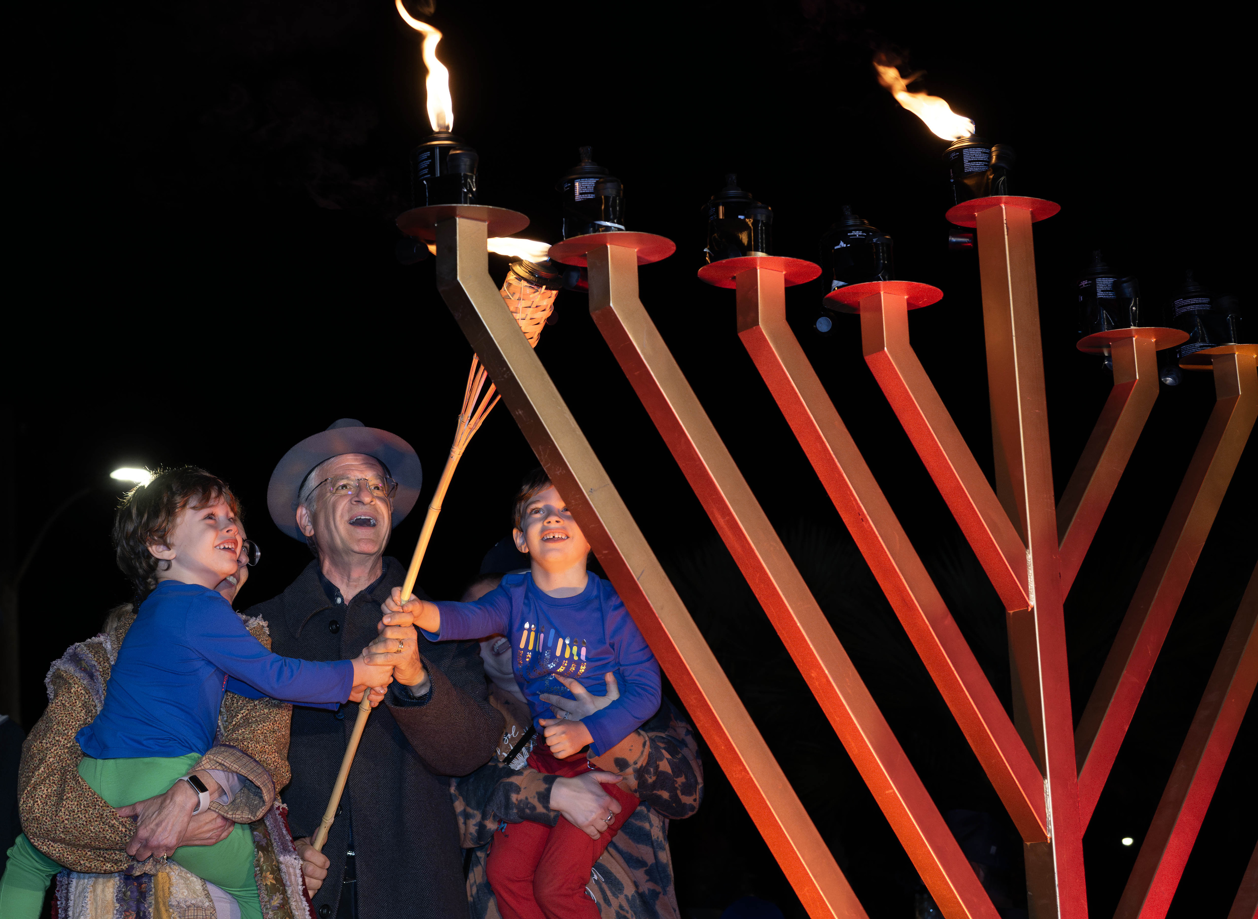 Teri and Jeffrey Roth help their 5-year-old grandsons Elias, left,...