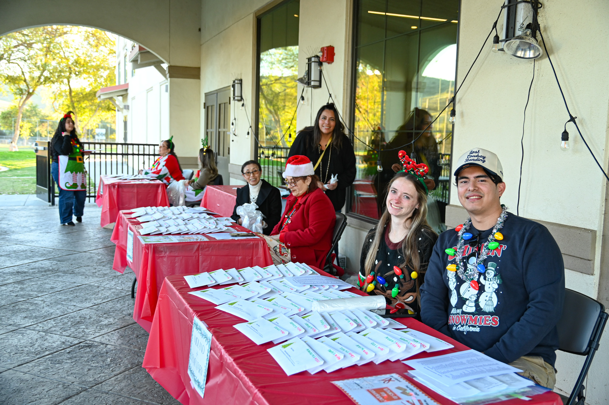 Front table volunteers Angela Weeks and David Guzman help with...