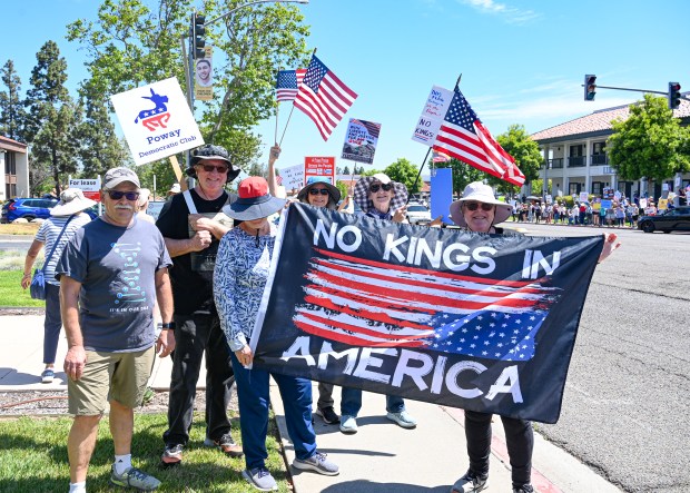 Members of the Poway Democratic Club. from left, Nick Carruthers, Ron Chapman and Linda Carruthers at the No Kings protest on June 14 in Rancho Bernardo. (Criselda Yee)
