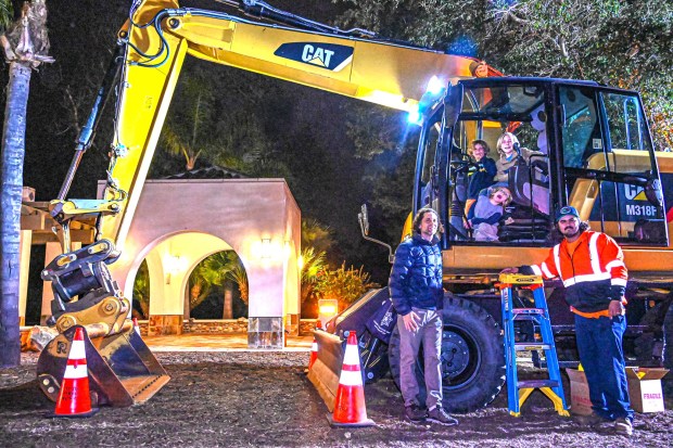 Siblings Leif, Finn and Niels Sathrum explored the cab of the wheeled excavator while dad Aaron Sathrum and James Barsanti from Poway Stormwater Maintenance stood close by. (Criselda Yee)
