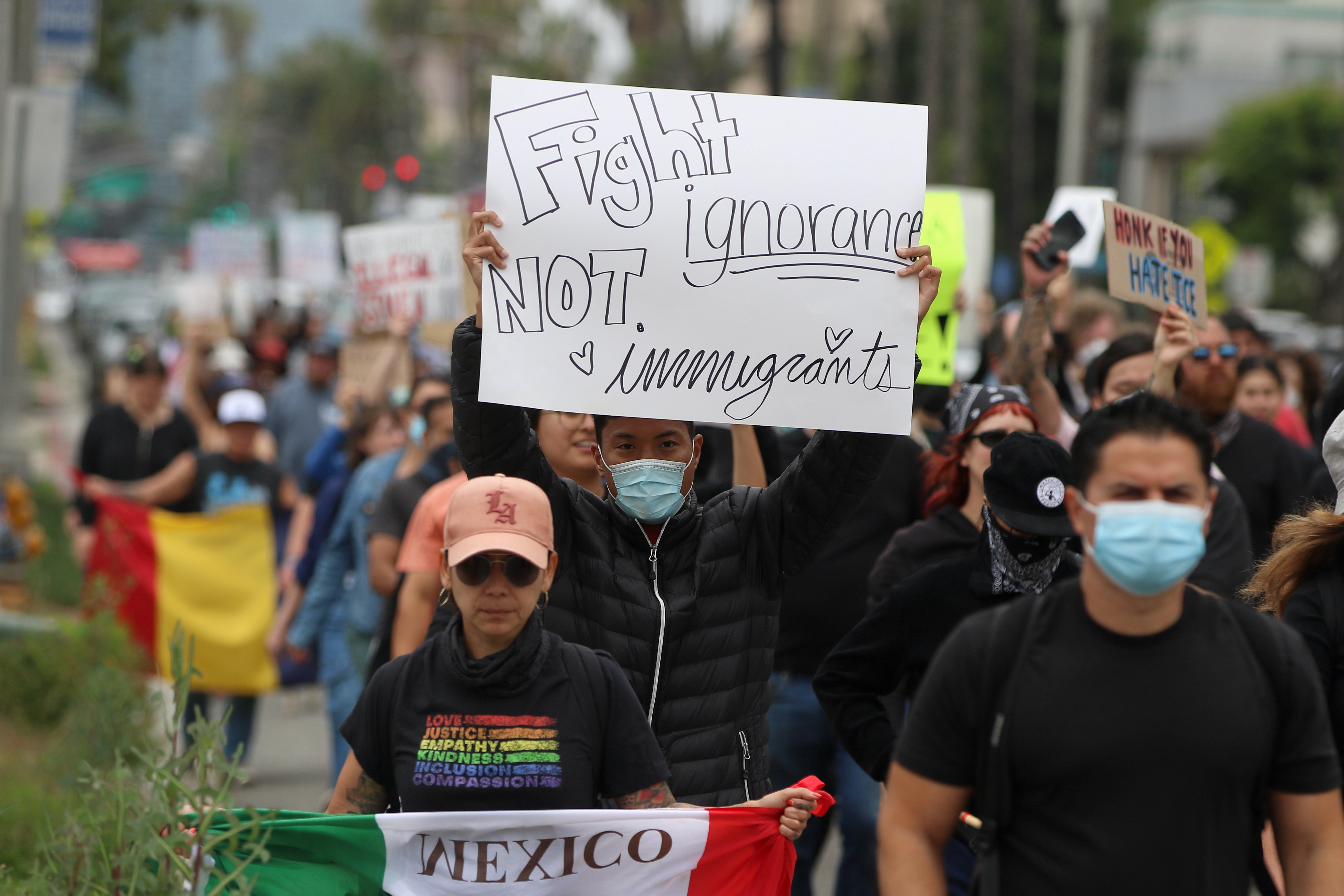 Dozens of protesters shouting anti-ICE chants march along Ocean Boulevard...