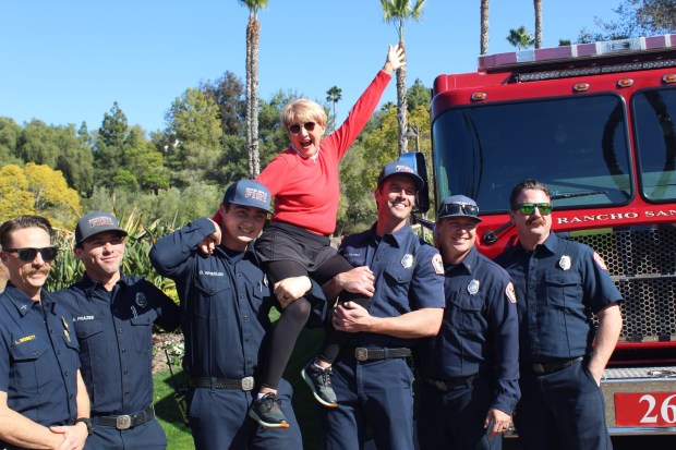 RSF firefighters hoist up M Bolyard, the Crosby Women's Golf Club's Ace of the Year. (Karen Billing)