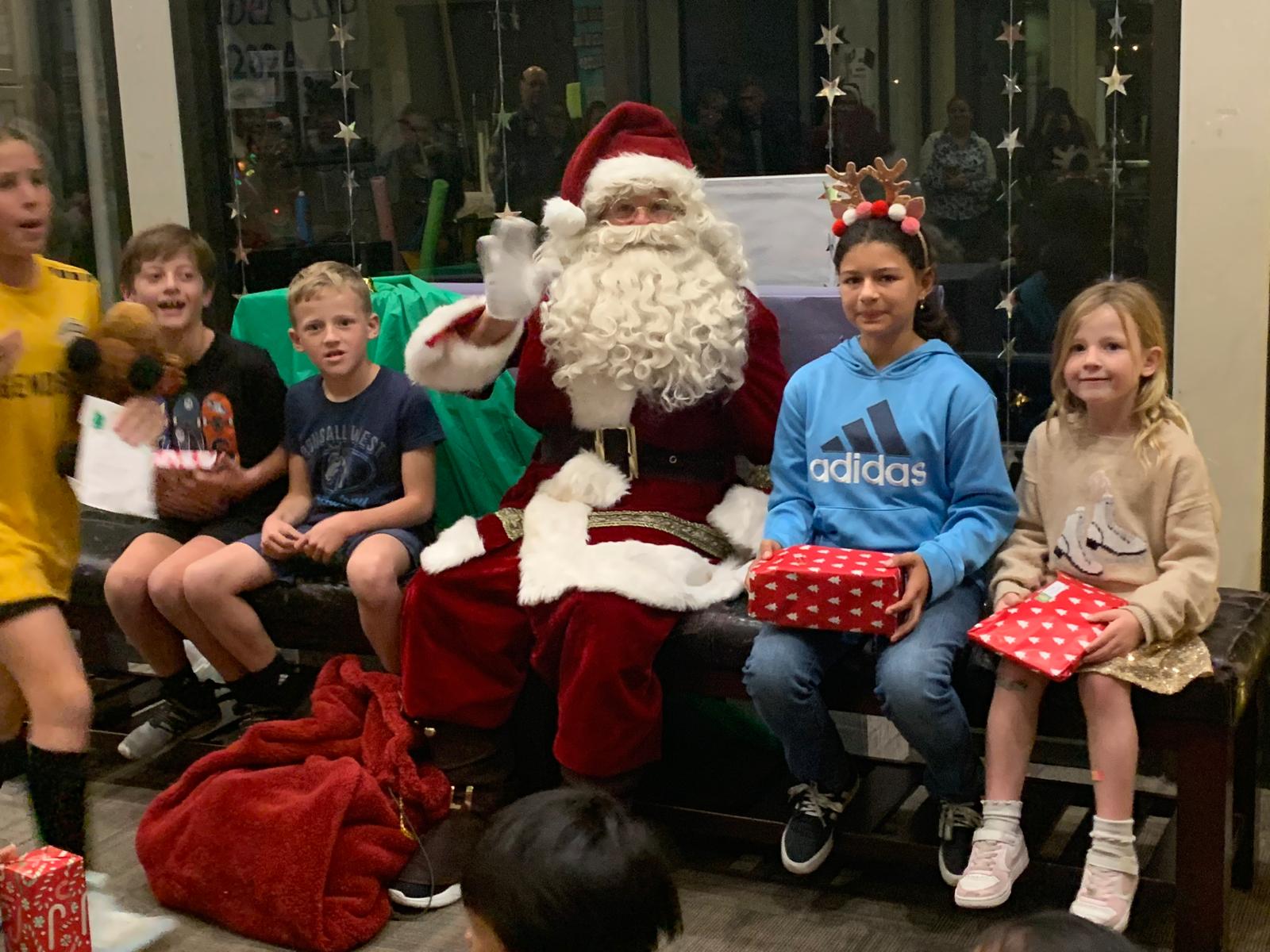 Santa (Paul Mears) and children (Photos by Taylor Miller and...