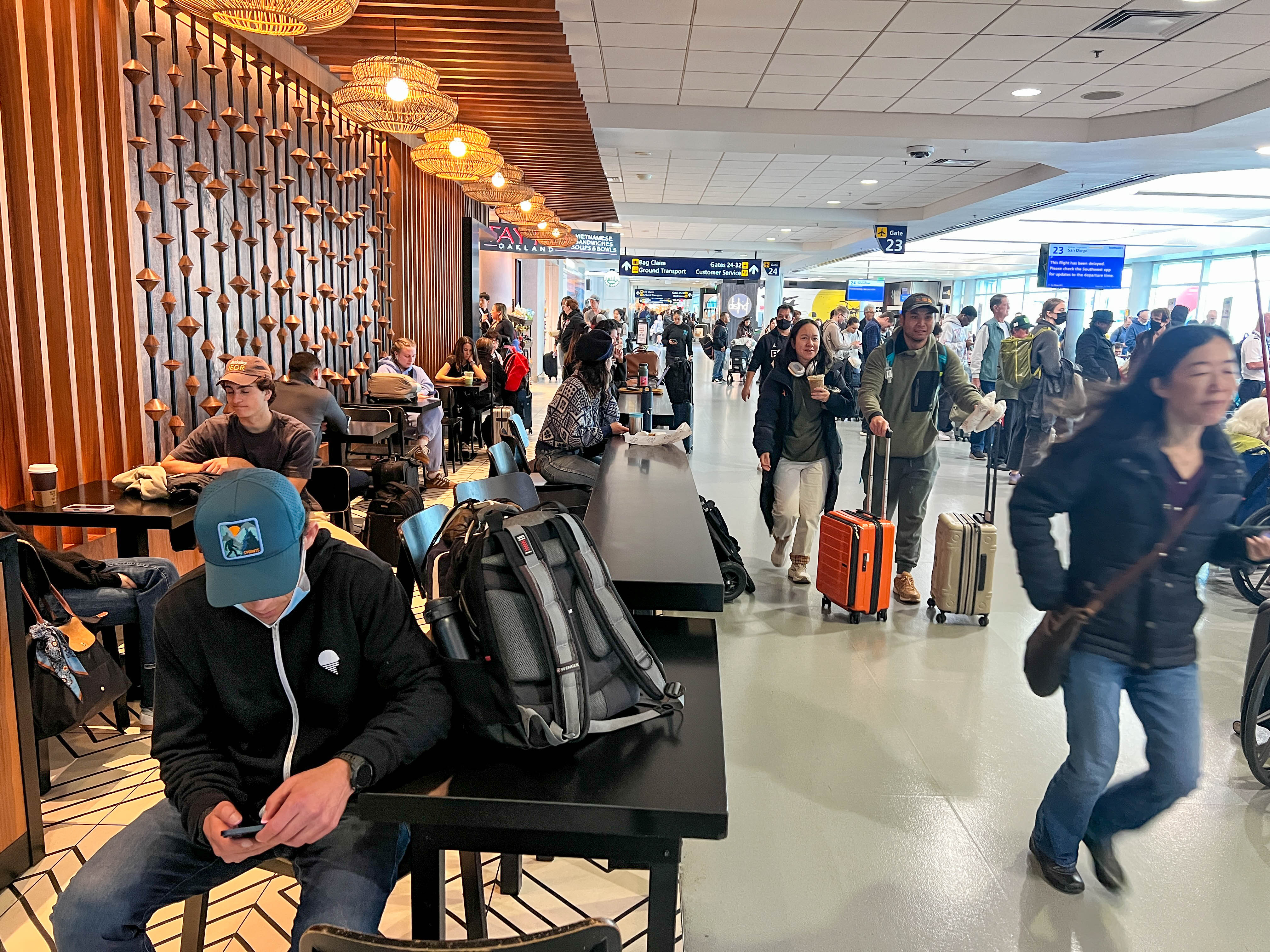 Travelers wait to board their flight at the Oakland San...