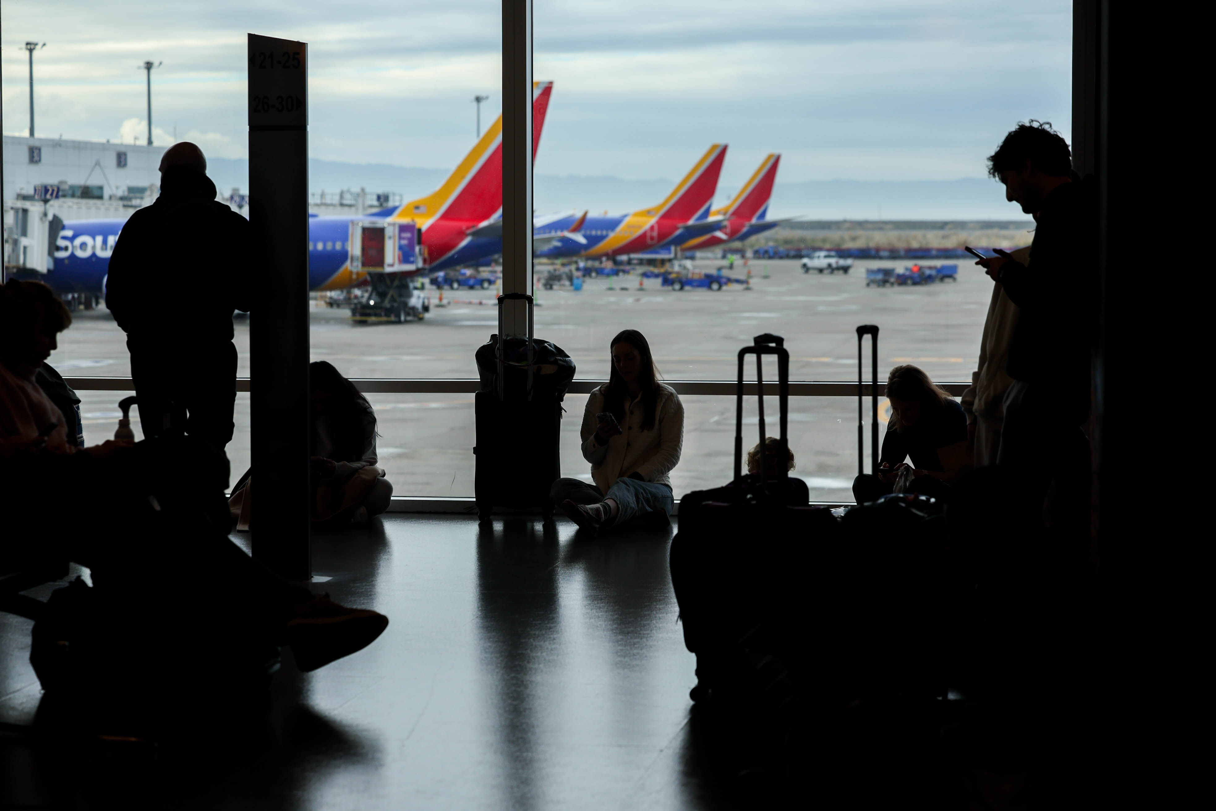 Travelers wait to board their flight at the Oakland San...