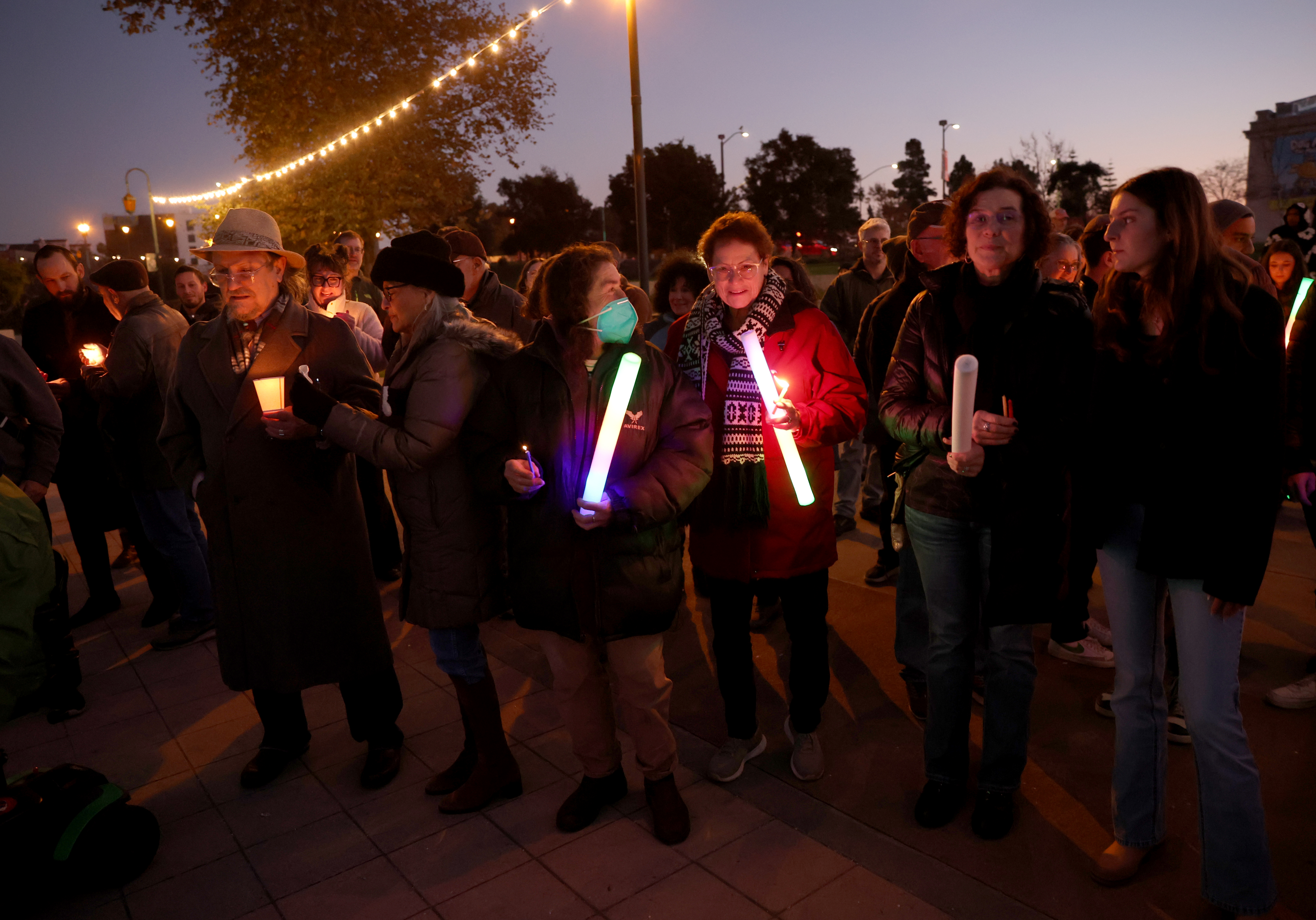 Community members take part in a Hanukkah menorah-lighting ceremony at...