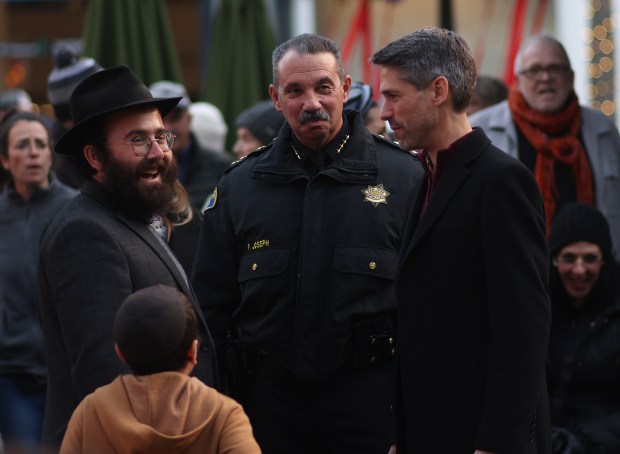 Mayor Matt Mahan, right, and Police Chief Paul Joseph, center, visit with community members on the first night of Hanukkah for a menorah lightning ceremony at Santana Row on Sunday, Dec. 14, 2025, in San Jose, Calif. (Aric Crabb/Bay Area News Group)