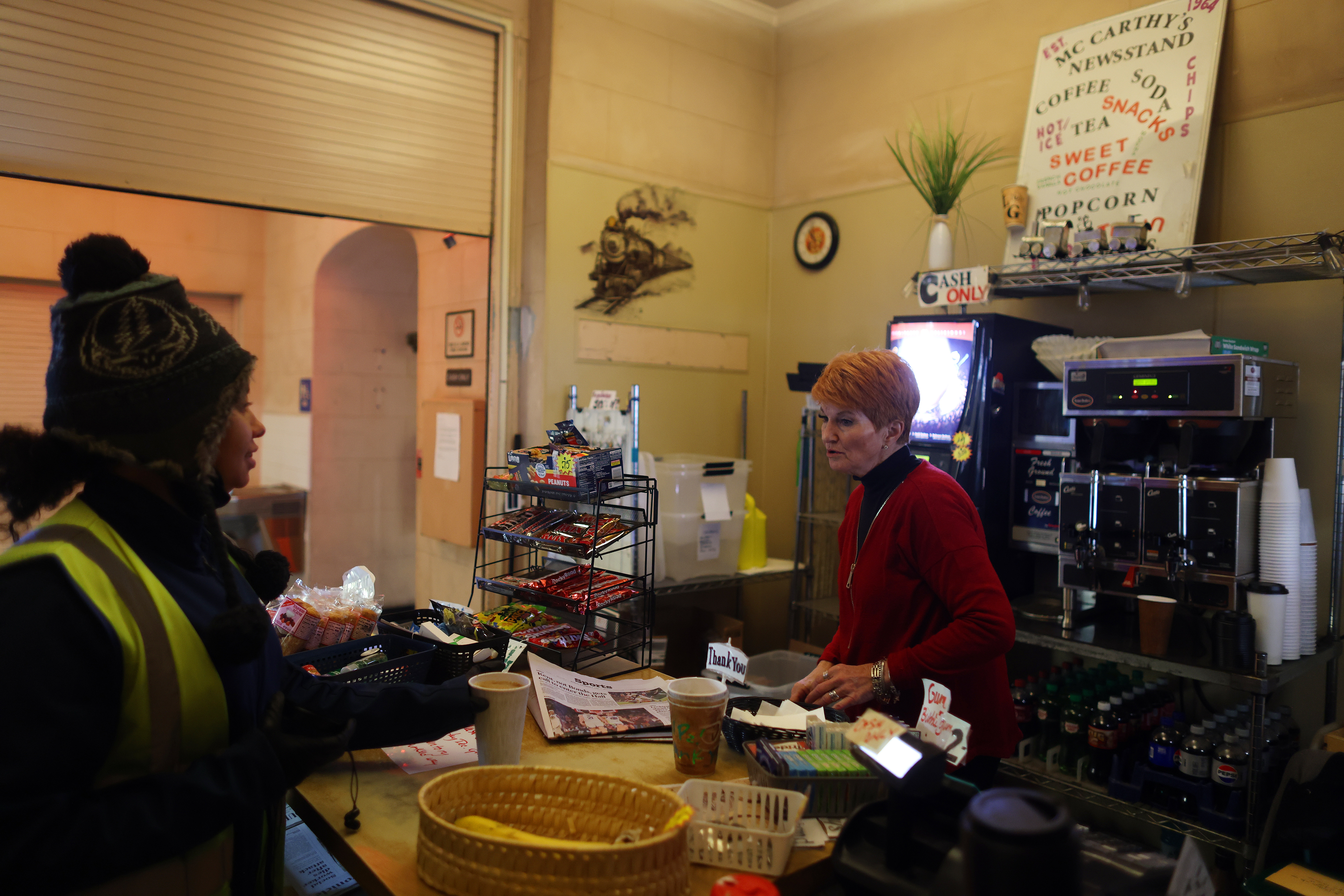 Anne Zingale, right, owner of McCarthy's Newsstand serves coffee to...
