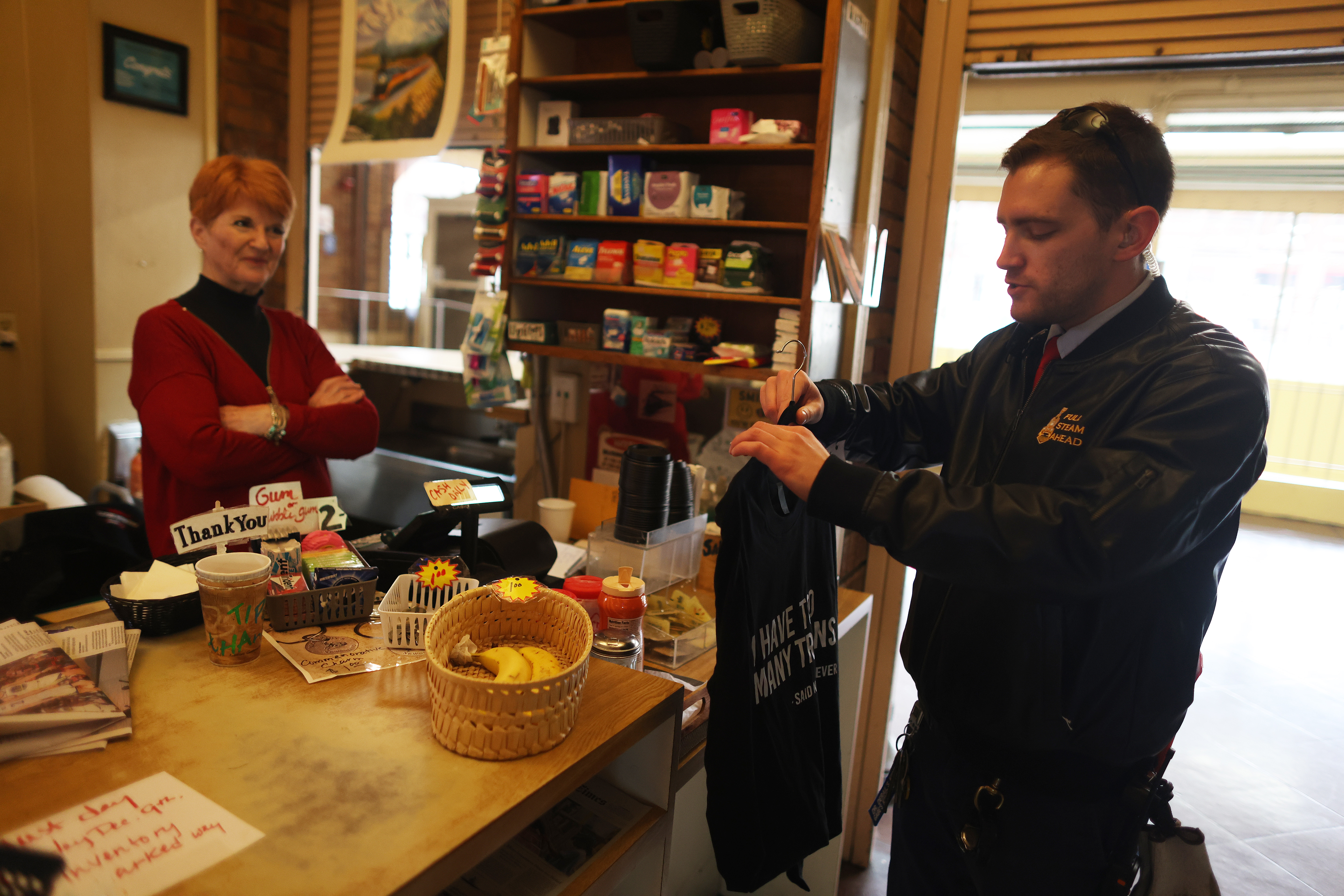 Anne Zingale, left, owner of McCarthy's Newsstand sells a shirt...