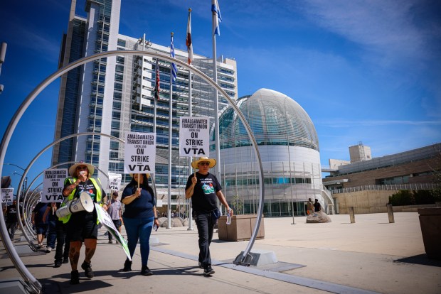A rally of ATU members walks along the sidewalk past San Jose City Hall in downtown San Jose, Calif., on Tuesday, March 25, 2025. (Shae Hammond/Bay Area News Group)