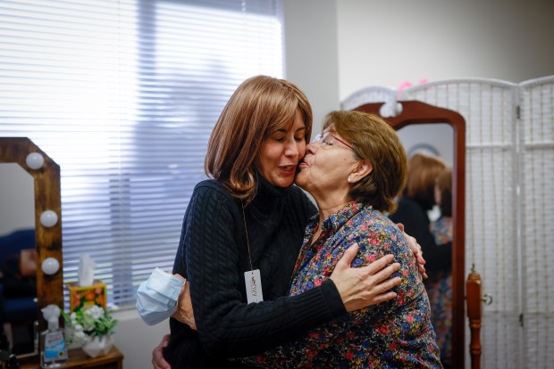 Gilma Pereda, of Santa Clara, left, receives kisses from her mom Martha Sanchez, right, at Cancer CAREpoint's office in San Jose, Calif., on Thursday, Oct. 23, 2025. Pereda was diagnosed with cervical cancer in 2016 then by metastatic recurrence cancer was found in her lung and bones and there was a recent finding of a possible tumor in her brain. (Shae Hammond/Bay Area News Group)