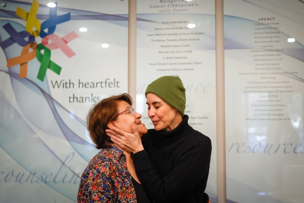 Gilma Pereda, of Santa Clara, right, kisses her mom Martha Sanchez, left, at Cancer CAREpoint's office in San Jose, Calif., on Thursday, Oct. 23, 2025. Pereda was diagnosed with cervical cancer in 2016 then by metastatic recurrence cancer was found in her lung and bones and there was a recent finding of a possible tumor in her brain. (Shae Hammond/Bay Area News Group)