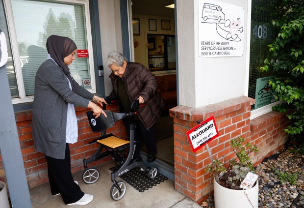 Alma Soto, Executive Director of Heart of the Valley, helps Lidia Donez out the front door of their office in Santa Clara, Calif., on Wednesday, Oct. 15, 2025. Wish Book for Heart of the Valley Services for Seniors. (Nhat V. Meyer/Bay Area News Group)