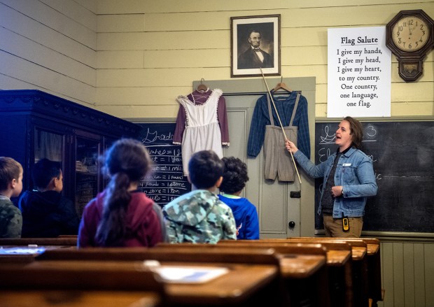 Terrell Elementary School students listen to Eric Pfanhl museum educator inside the Santa Ana School, a former one-room schoolhouse originally located in Hollister, which is now located at History San Jose, to educate children on how classes were held in the 1890s, during a school tour of the park in San Jose, Calif., on Wednesday, Oct. 15, 2025. (Doug Duran/Bay Area News Group)