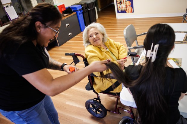 Client Consuelo Villicana, center, smiles as Assistant Program Director Berenice Aguilar, left, entertains her with a joke at Live Oak Adult Day Services in San Jose, Calif., on Nov. 4, 2025. (Dai Sugano/Bay Area News Group)