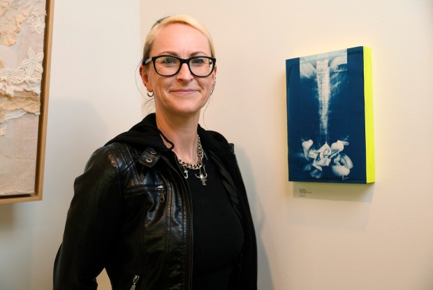 Artist Janet Appleton poses for a photograph next to her artwork titled "Spinal Lily," a cyanotype mounted on wood," at the Noble Workshop & Gallery in downtown San Jose, Calif., on Thursday, Oct. 16, 2025. Wish Book for Local Color. (Nhat V. Meyer/Bay Area News Group)