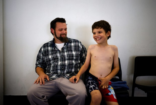 Lucas Foreman, 9, from San Jose, waits with his father Jason before Lucas' Safety Around Water swim class at the Southwest YMCA in Saratoga, Calif., on Monday, Oct. 26, 2025. Wish Book for the YMCA Safety Around Water program. (Nhat V. Meyer/Bay Area News Group)