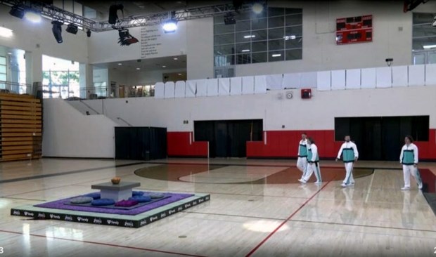 Video from the livestream posted online shows people in costume using the gym, with the school's ravens mascot visible on a wall in the background. (PaymoneyWubby, Fansly)