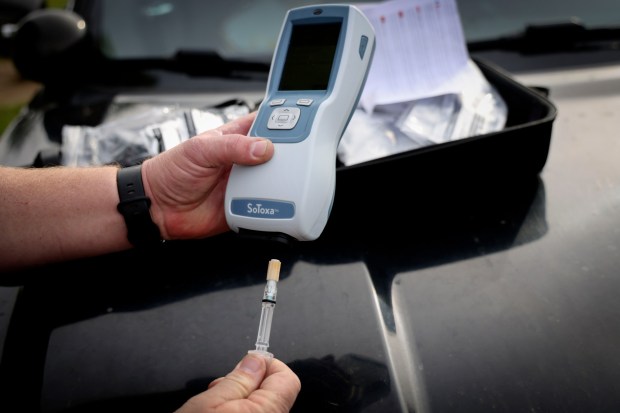 SDPD officer Anthony Bueno displays the departments new SoToxa, a small device which tests saliva to detect several types of drugs, on Monday, December 22, 2025 at their Murphy Canyon facility..( Photo by Sandy Huffaker for The San Diego Union-Tribune)