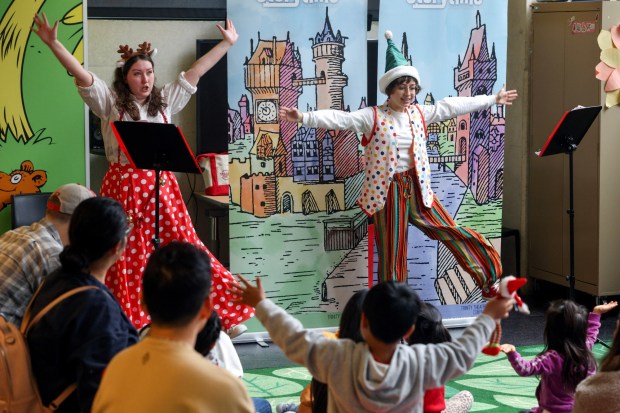 Astrid Pett, left, and Sophia Seafidi of the Trinity Theatre Company act out "The Littlest Reindeer" for children at the San Diego Central Library on Saturday, Dec. 20, 2025. (Hayne Palmour IV / For The San Diego Union-Tribune)
