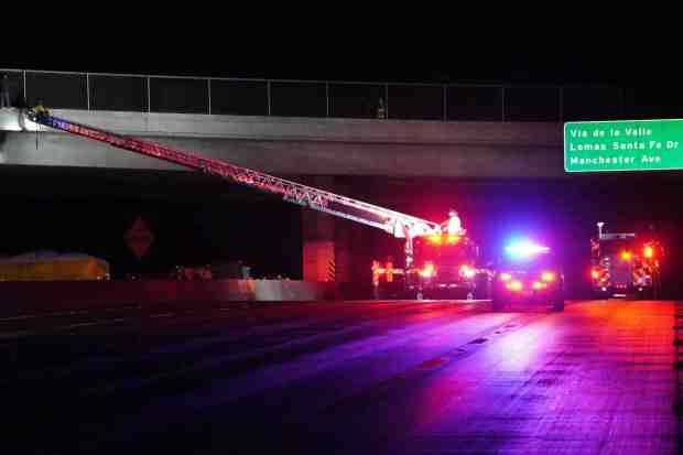 ....Firefighters and police officers are on scene as a man attempts to jump off from the bridge to I-5 near Del Mar Heights Road on Friday, Dec. 5, 2025 in San Diego, CA. (Michael Ho / For The San Diego Union-Tribune)