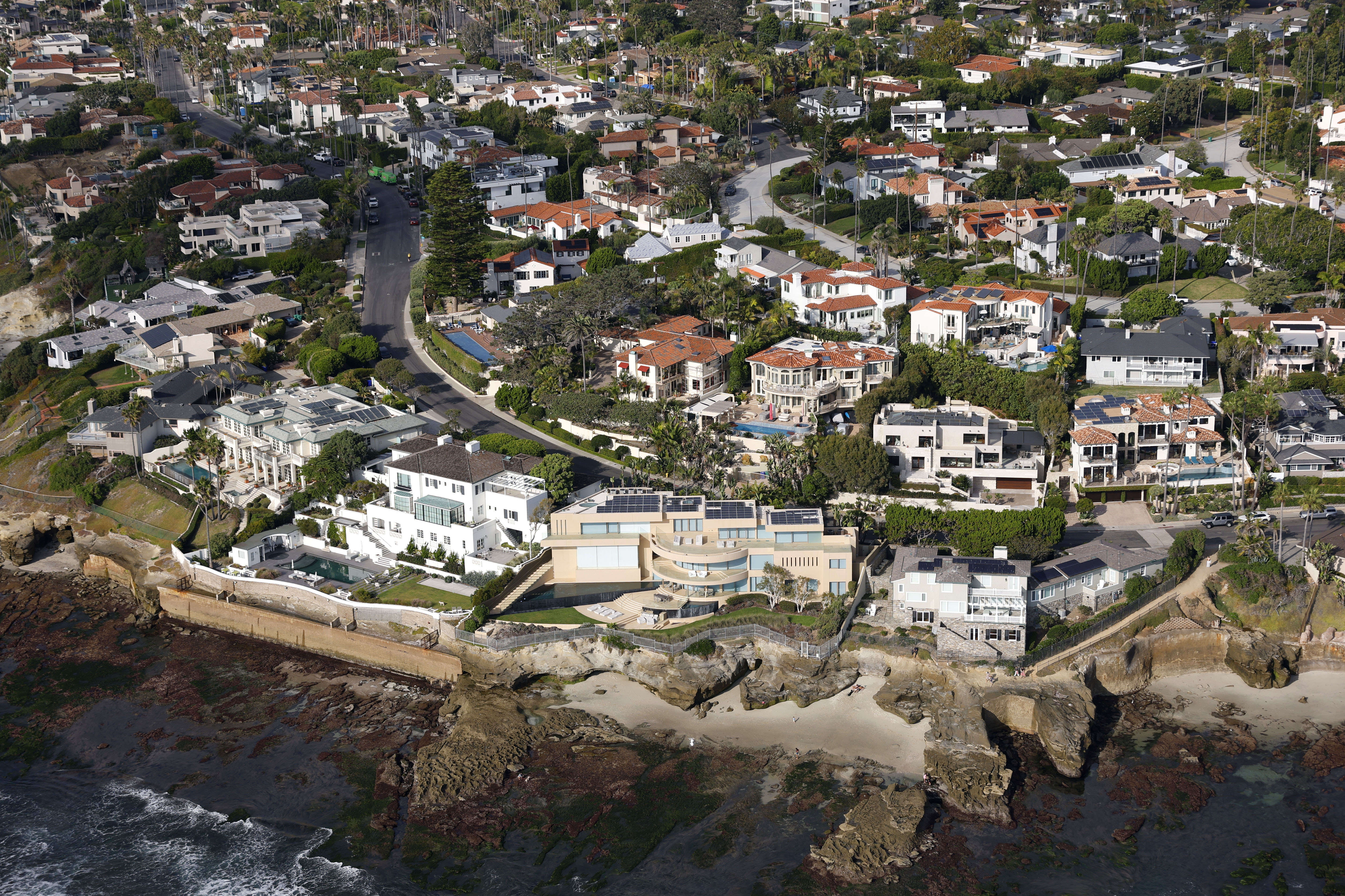 In an aerial photo, luxury homes line the coast of...
