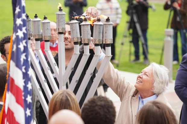 San Diego County Sheriff Kelly A. Martinez, far right, lights up the six-foot Menorah during the Rally for Light, a Hanukkah Celebration of Unity and Resilience at the County of San Diego Administration Center on Monday, Dec. 22, 2025 in San Diego, CA. (Michael Ho / For The San Diego Union-Tribune)