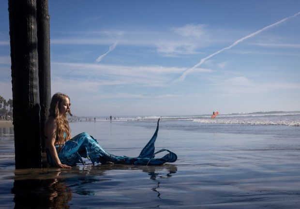 Tiffany Turner, 36, of Utah, poses as a mermaid under the Oceanside Pier in late November. (Ana Ramirez / The San Diego Union-Tribune)