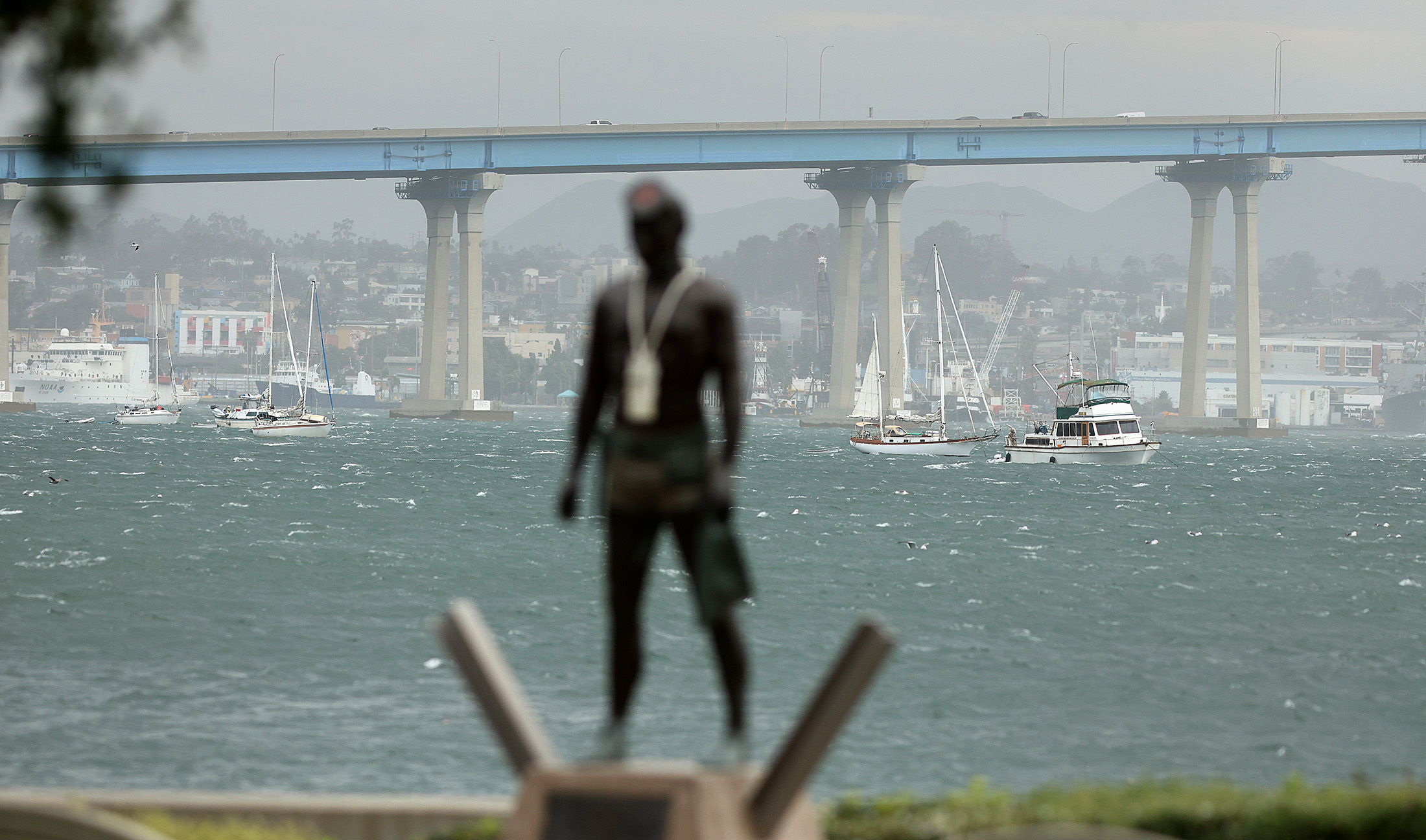 Whitecaps formed in windy weather and stressed sailboats at anchor...