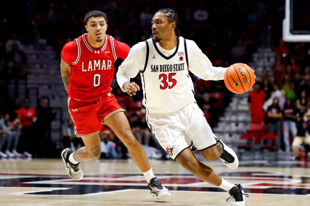 SDSU sophomore Taj DeGourville, after swapping his No. 24 jersey for No. 35, dribbles against Lamar's Cody Pennebaker on Wednesday night. (Meg McLaughlin / The San Diego Union-Tribune)