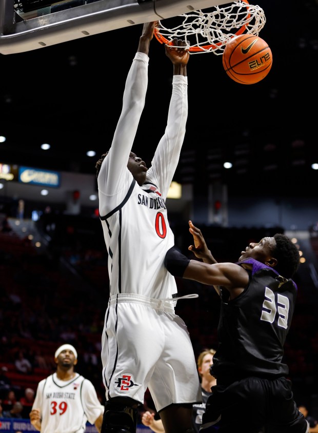 San Diego, CA - December 22: Magoon Gwath #0 of San Diego State dunks against Tochi Onyeador #33 of Whittier at Viejas Arena on December 22, 2025 in San Diego, CA. (K.C. Alfred / The San Diego Union-Tribune)