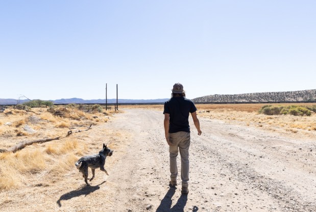 Pete Cerep, 37, walks his property with one of his cattle dogs in late October in Jacumba Hot Springs.(Ana Ramirez / The San Diego Union-Tribune)