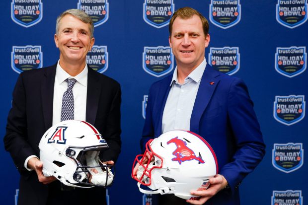 Arizona head coach Brent Brennan and SMU head coach Rhett Lashlee pose for a photo during a press conference ahead of the 2025 Holiday Bowl, at the Manchester Grand Hyatt on Tuesday, Dec. 16, 2025 in San Diego, California. (Meg McLaughlin / The San Diego Union-Tribune)