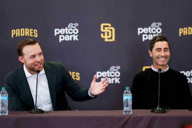 Michael King, left, speaks during a news conference after the Padres re-signed him to a three-year, $75-million contract as President of baseball operations A.J. Preller, right, laughs at Petco Park on Friday, Dec. 19, 2025 in San Diego, California. (Meg McLaughlin / The San Diego Union-Tribune)