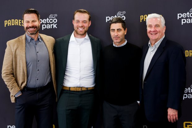 Padres CEO Erik Greupner, pitcher Michael King, president of baseball operations A.J. Preller and chairman John Seidler pose for a photo during a news conference announcing that the team re-signed King to a three-year, $75-million contract at Petco Park on Friday, Dec. 19, 2025 in San Diego, California. (Meg McLaughlin / The San Diego Union-Tribune)