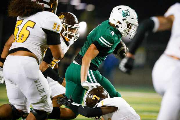 Oceanside's EZ Tokio (4) runs the ball against El Camino's Qayden Coleman (7) during their game at Oceanside High School on Friday, Sept. 27, 2024 in Oceanside, CA. (Meg McLaughlin / The San Diego Union-Tribune)