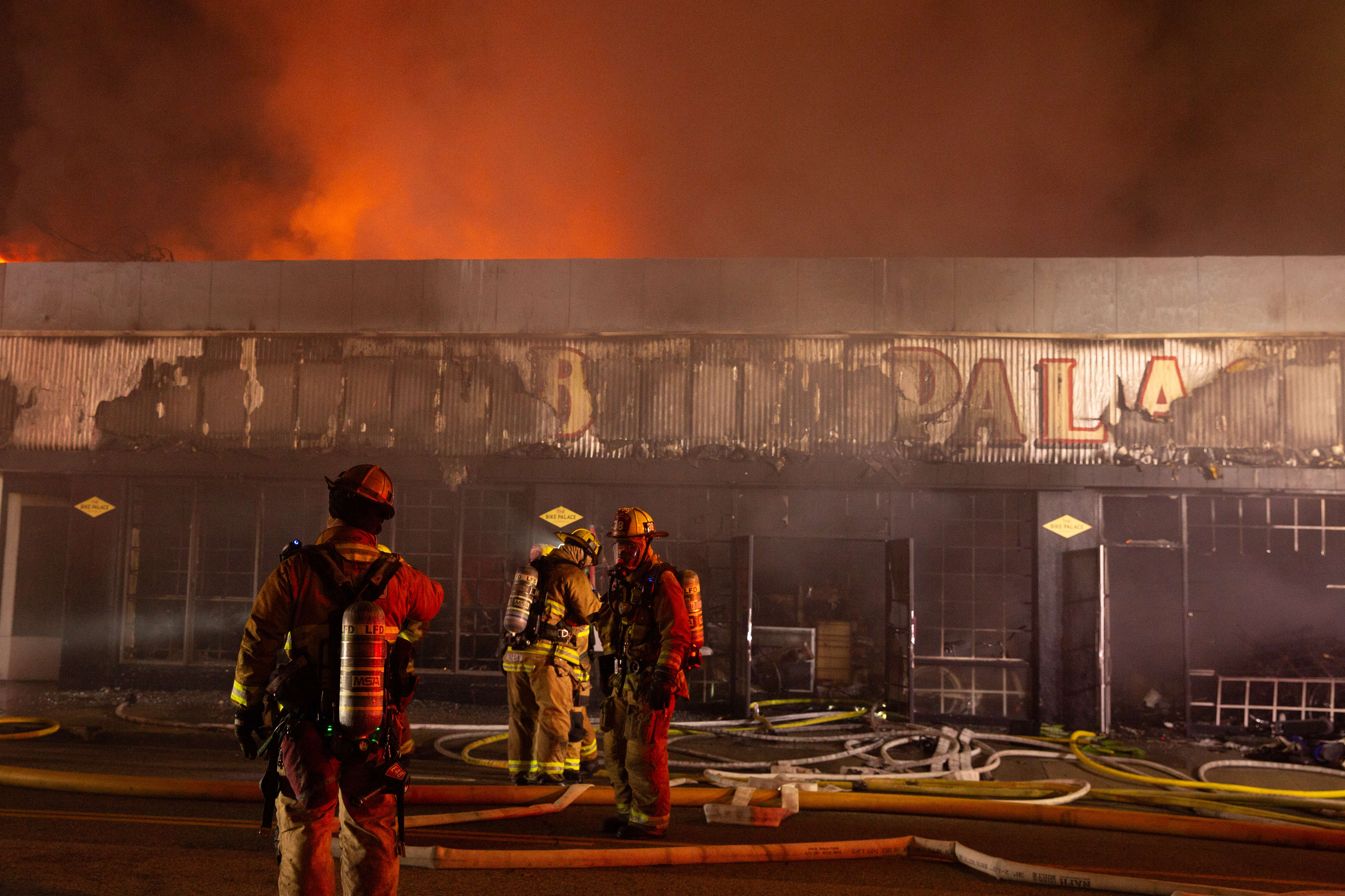 Firefighters battle a blaze in The Bike Palace bicycle shop...