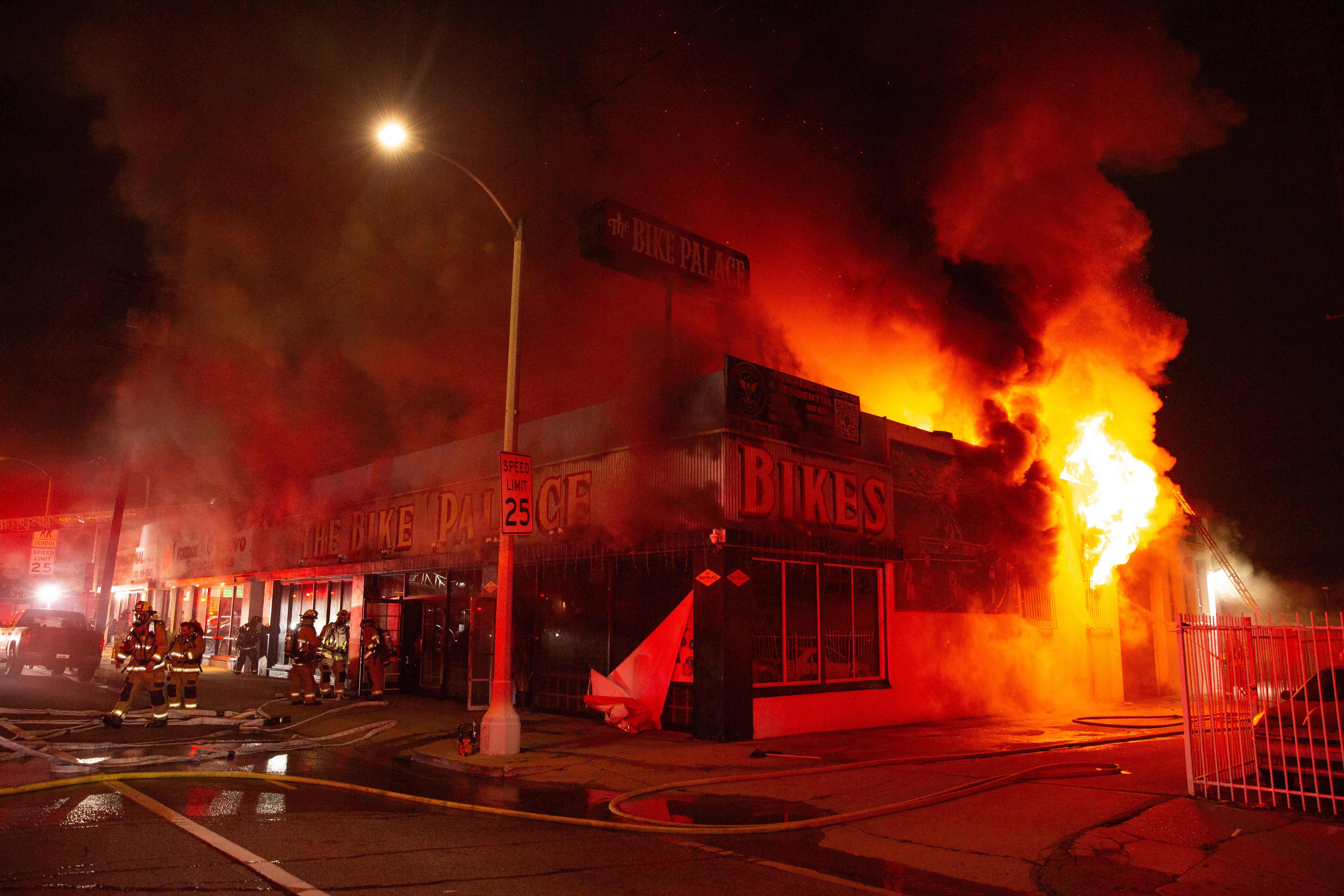 Firefighters battle a blaze in The Bike Palace bicycle shop...