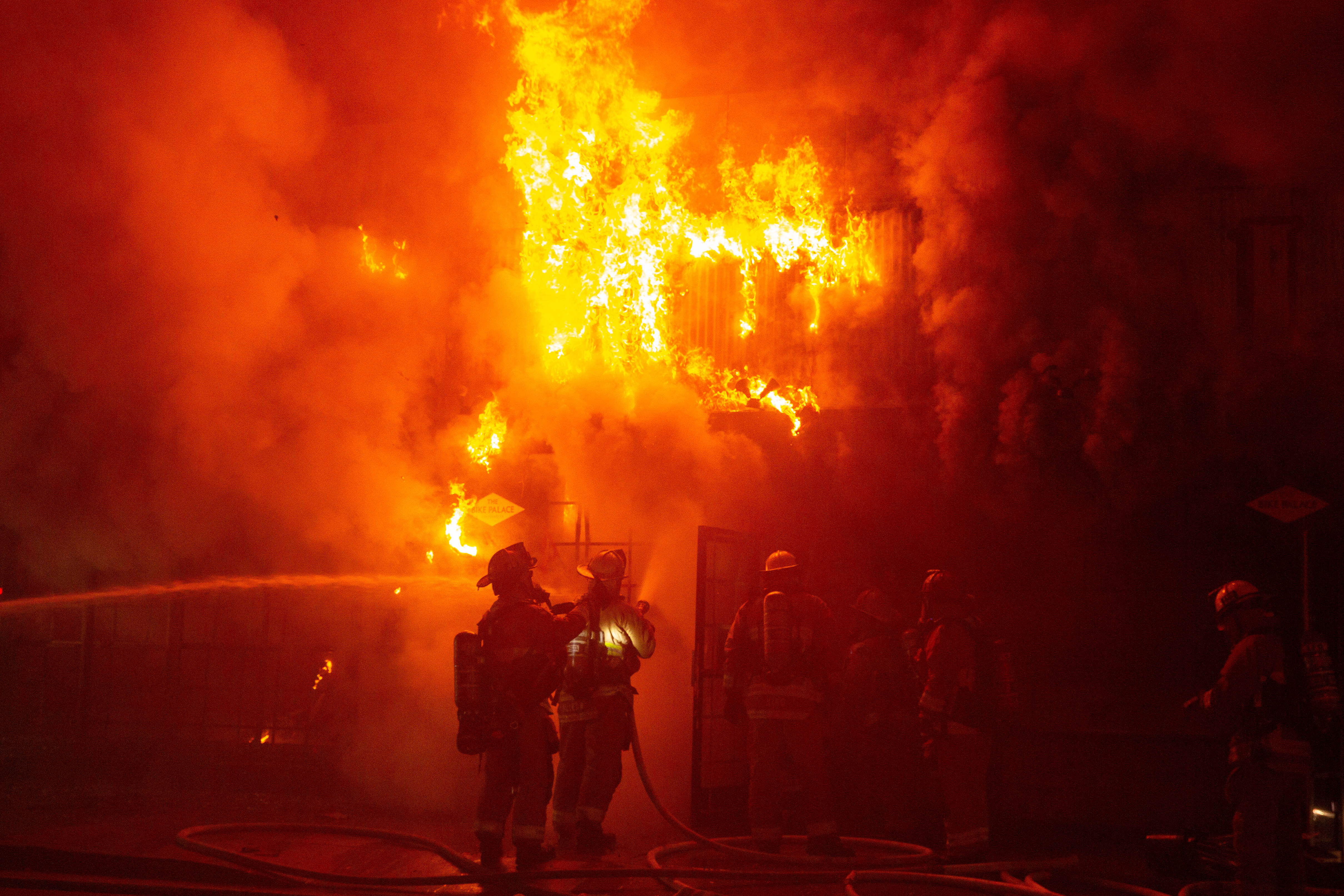 Firefighters battle a blaze in The Bike Palace bicycle shop...