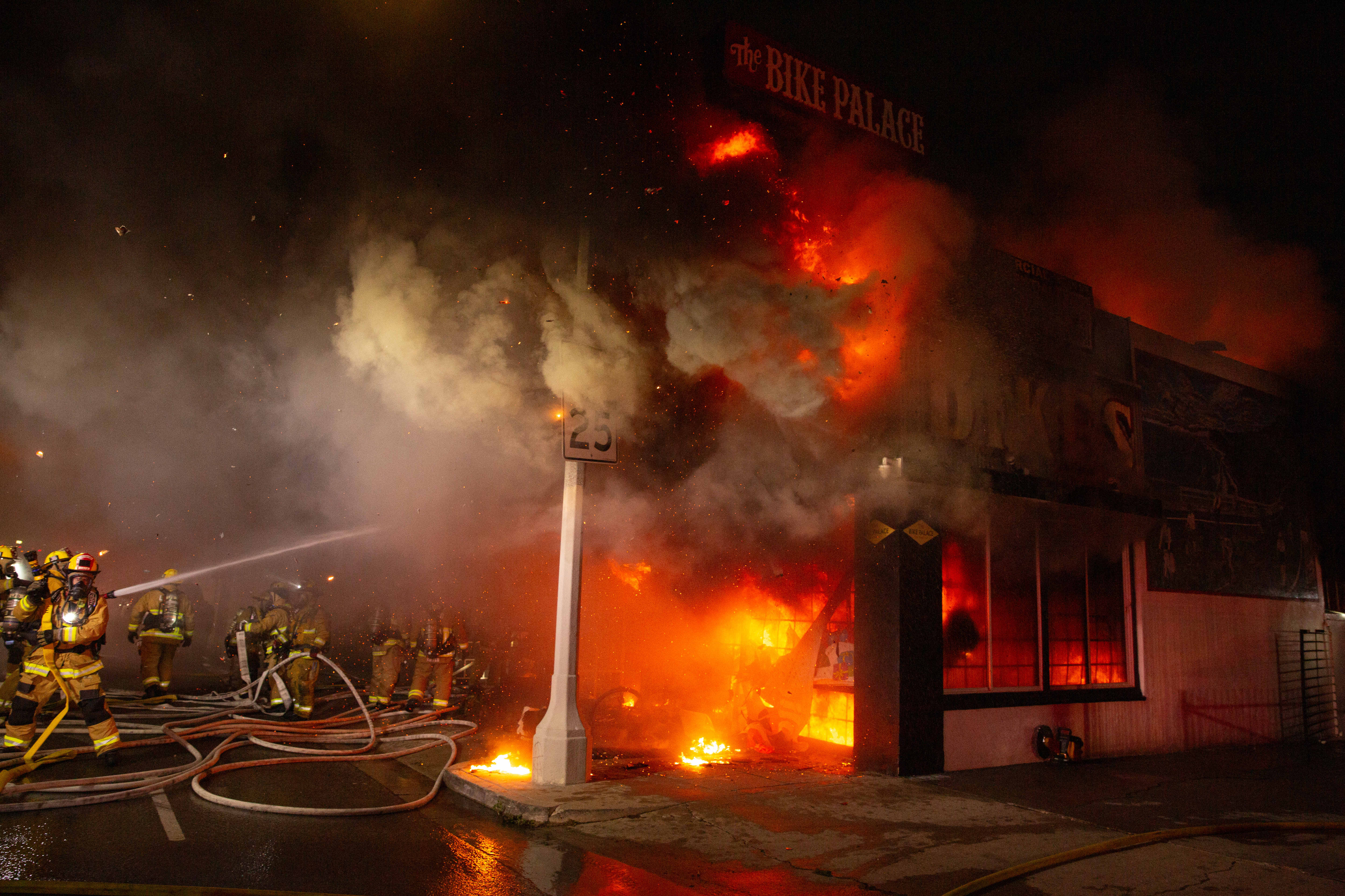 Firefighters battle a blaze in The Bike Palace bicycle shop...