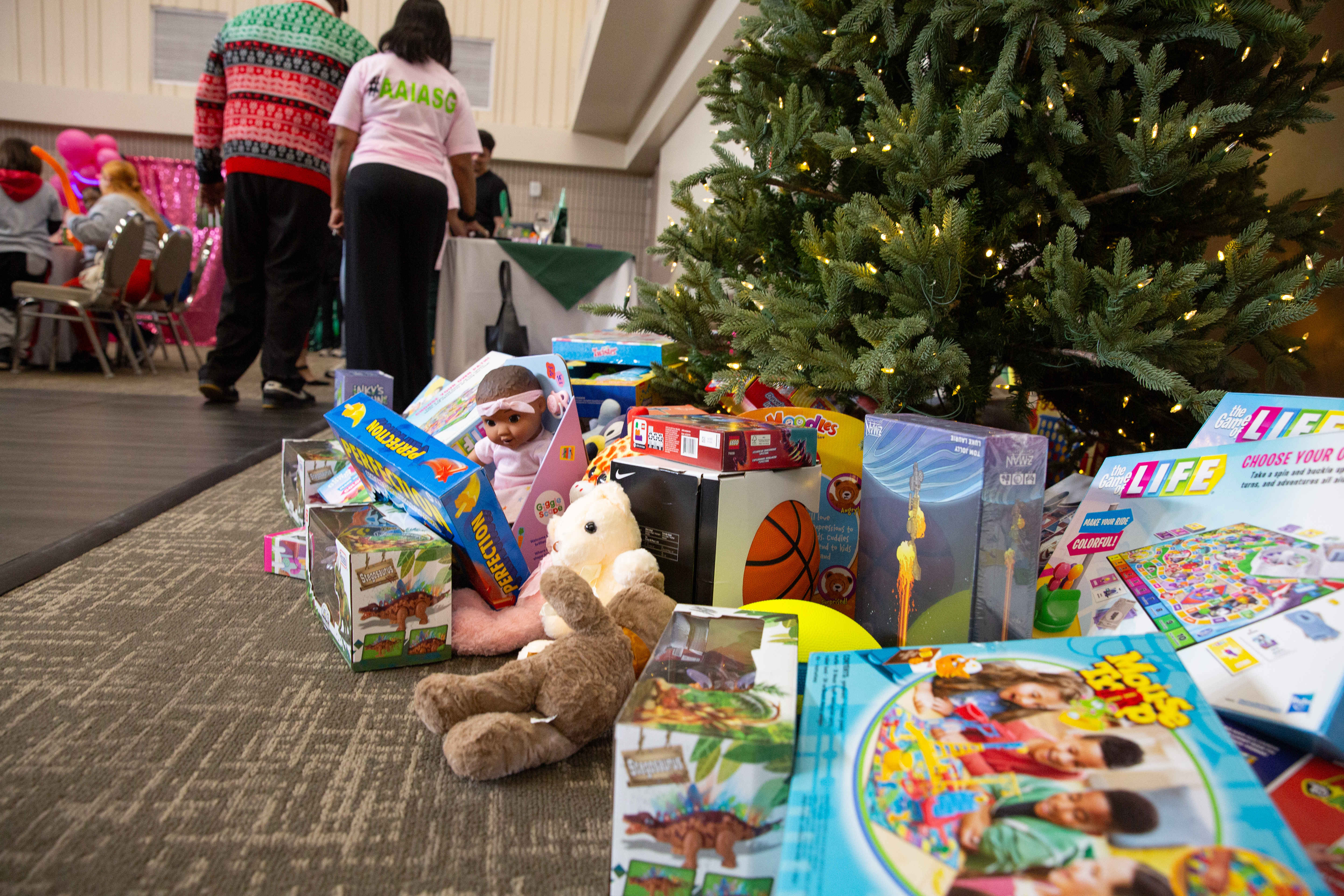 A pile of toys sits beneath a Christmas tree during...