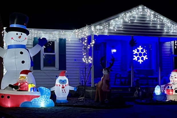 A giant snowman grins as passersby from this Donald Street holiday display in Royal Oak on Dec. 23, 2025. (Peg McNichol/MediaNews Group)