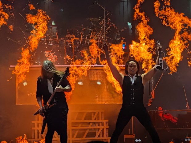 flames behind two musicians on stage