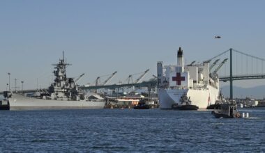 The USNS Mercy, right, passes the USS Iowa Museum as it enters the Port of Los Angeles, Friday, March 27, 2020, in Los Angeles. (AP Photo/Mark J. Terrill)