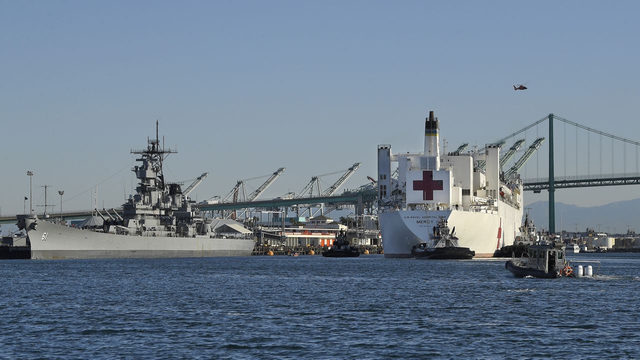 The USNS Mercy, right, passes the USS Iowa Museum as it enters the Port of Los Angeles, Friday, March 27, 2020, in Los Angeles. (AP Photo/Mark J. Terrill)