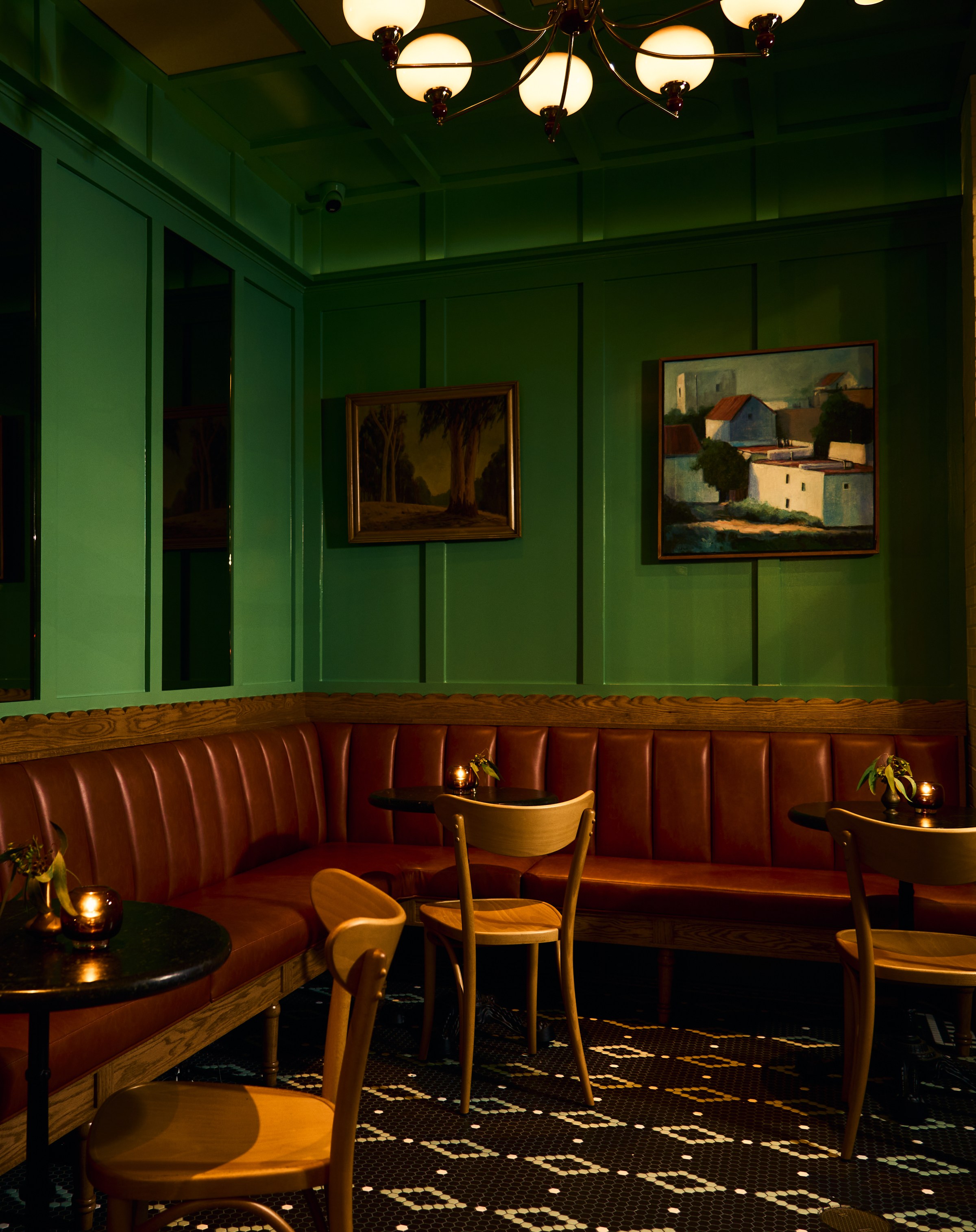 Room painted green with leather booths at Vandell