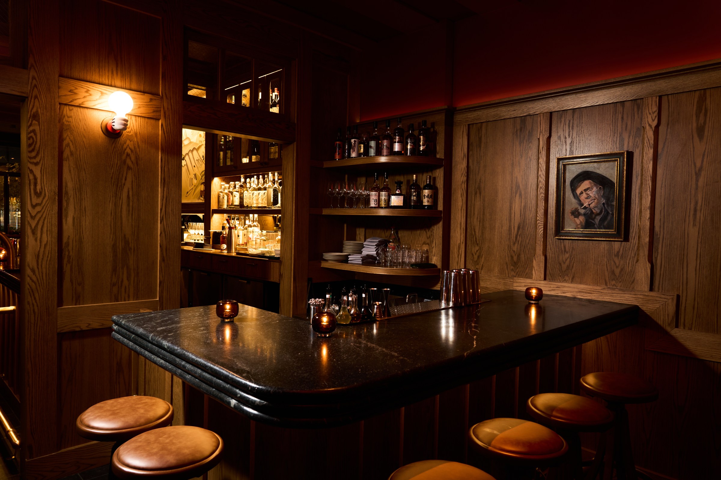 Back bar at Vandell with a handful of stools and dim lighting.