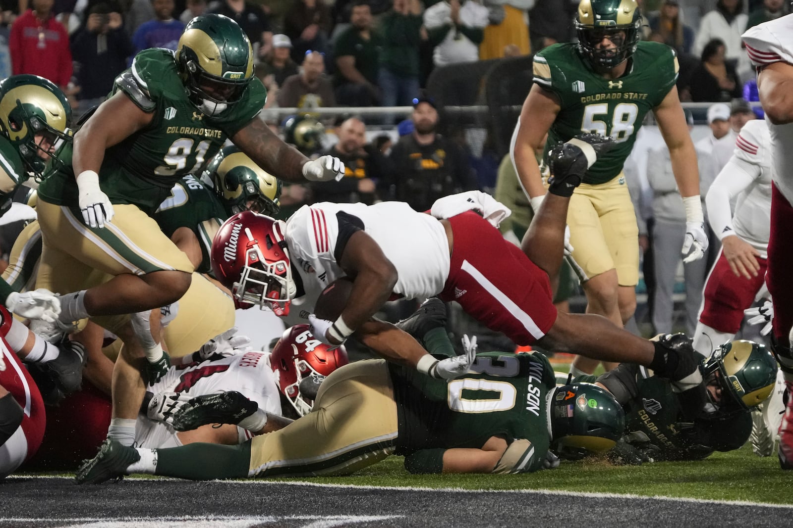 Miami (Ohio) running back Jordan Brunson, center top, scores a touchdown against Colorado State in the second half of the Arizona Bowl NCAA college football game, Saturday, Dec. 28, 2024, in Tucson, Ariz. (AP Photo/Rick Scuteri)