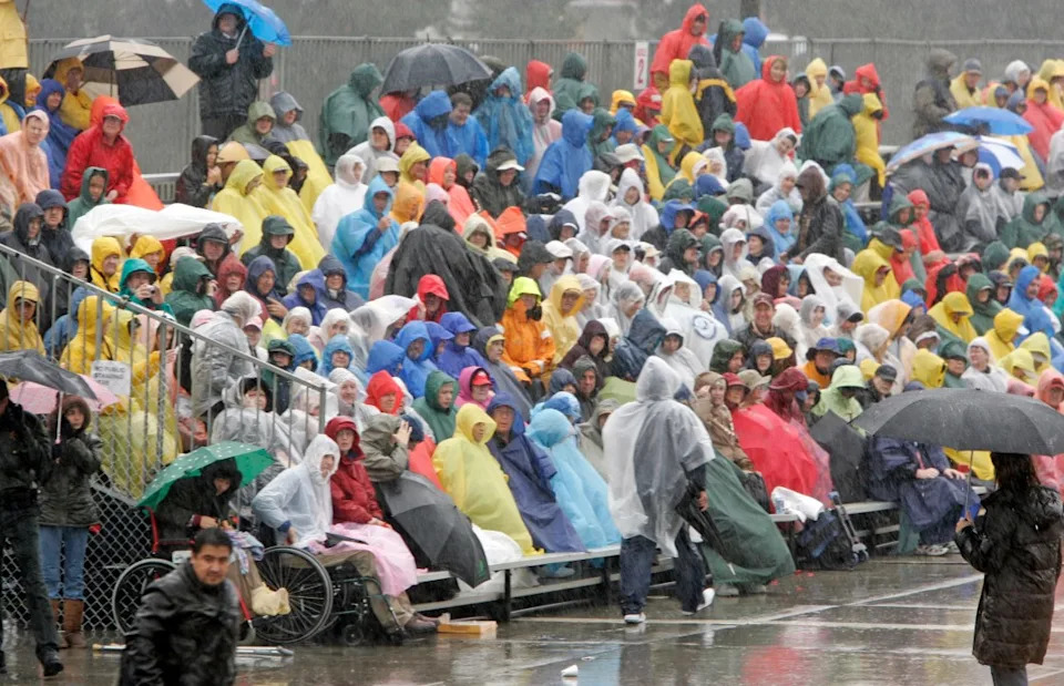 A crowd gathers in the pouring rain along Colorado Boulevard to watch the 117th Annual Rose Parade on Monday, Jan. 2, 2006, in Pasadena, Calif. It rained on the Rose Parade for the first time in more than a half century and hundreds left the floral spectacle before it was finished. (AP Photo/Kevork Djansezian)