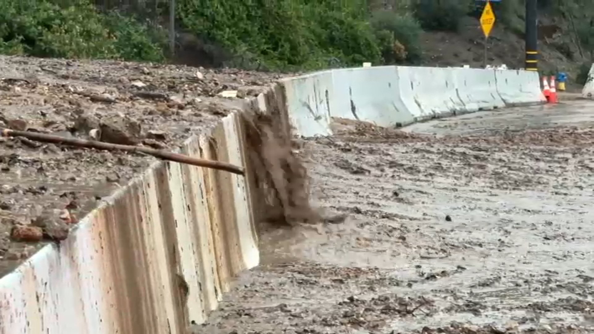 A stream of mud flooded a roadway in Altadena.